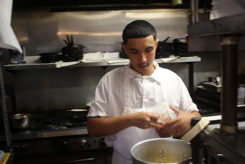 Christian in chef whites, working at the stove in a restaurant kitchen